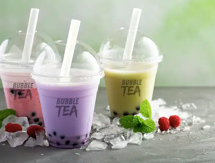 Bubble tea de fresa, taro y matcha en vasos personalizados con tapa c&uacute;pula, hielo y frutos rojos