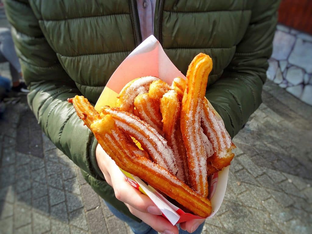 crispy churros covered with sugar held outdoors 2026 09 21 06 28 11 utc