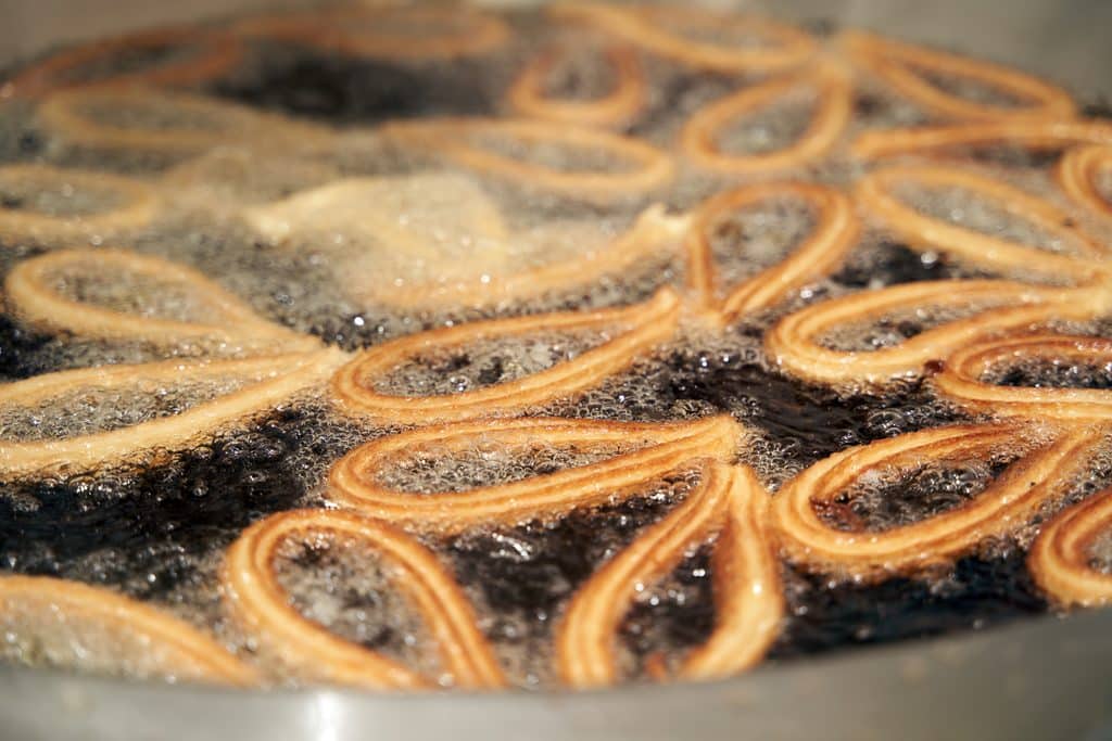 delicious churros frying in oil close up view 2026 09 23 06 40 27 utc