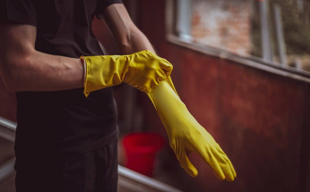 hands putting on yellow gloves for cleaning 2026 03 19 22 50 11 utc