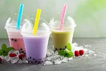 Tres bubble tea de colores en vasos de PET transparentes con tapa c&uacute;pula y pajitas de colores