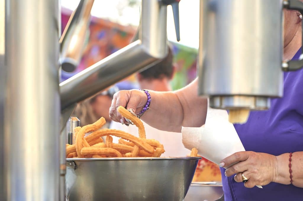 woman prepares and serves tasty churros at event 2026 09 21 07 38 34 utc